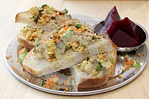 Delicious open-faced chicken salad sandwich with side of pickled beets