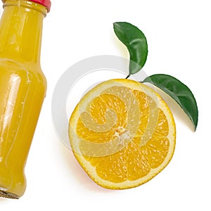 Delicious orange juice in a bottle and slice of orange next to it. Isolated on white. Top view