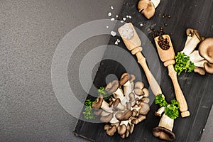 Delicious organic oyster mushrooms with spices and fresh parsley on wooden cutting board