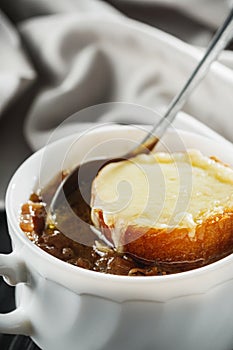 delicious original french onion soup on a black rustic wooden background