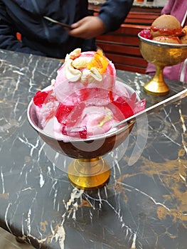 Delicious pakistani strawberry icecream in golden cup in quetta, pakistan photo