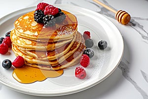 Delicious pancakes with berries, honey or maple syrup. Homemade pancakes and sweet syrup on white plate isolated.