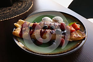 Delicious pancakes with fresh berries and ice cream on wooden table, closeup
