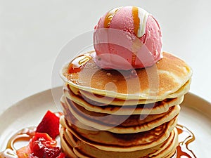 Delicious pancakes on plate with maple syrup and ice cream topping