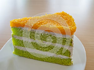 Delicious pandan and coconut cake with foi thong golden threads Thai dessert on white plate