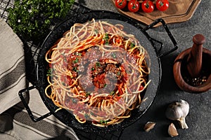 Delicious pasta with meatballs and tomato sauce near ingredients on grey table, flat lay