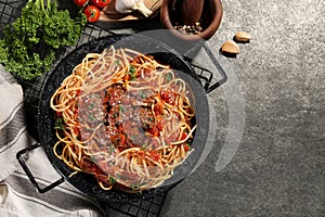 Delicious pasta with meatballs and tomato sauce near ingredients on grey table, flat lay. Space for text