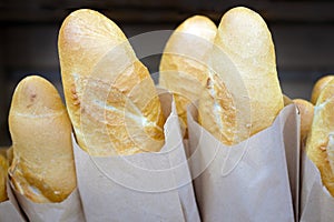 Delicious pastries french baguettes. Loaves of white bread in paper bags close-up.