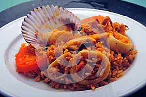 Delicious Peruvian dish of seafood rice. Cangrejo, guisantes, perejil, Prawns, scallops, mussels, clams, squid, red onion, and photo