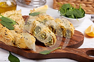 Delicious pie with spinach and feta cheese, made from filo pastry, decorated with sesame seeds