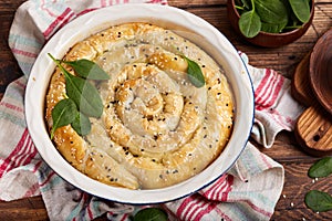 Delicious pie with spinach and feta cheese, made from filo pastry, decorated with sesame seeds