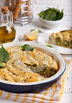 Delicious pie with spinach and feta cheese, made from filo pastry, decorated with sesame seeds