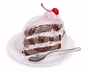 A delicious piece of chocolate cake with cherry cream and canned cherries on a white plate with a teaspoon, close-up