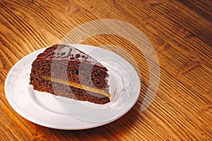 Delicious piece of Sacher cake on the wooden table