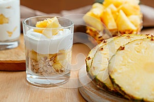 Delicious pineapple dessert. Breakfast dessert with oat granola, greek yogurt and pineapple in layers in glass with