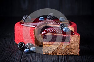 Delicious pink cake with berries on wooden table