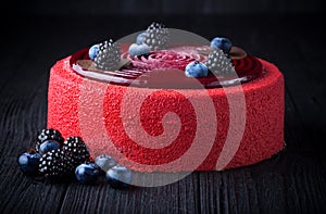 Delicious pink cake with berries on wooden table