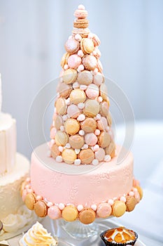 Delicious pink wedding cake decorated with macaroons
