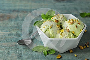 Delicious pistachio ice cream on blue wooden table