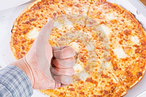 Delicious pizza with thumb up on the background of