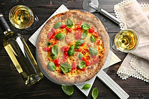 Delicious pizza with wine on table