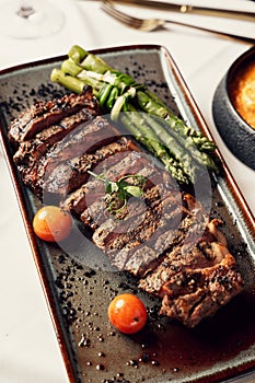 Delicious plate of Churrasco Steak, featuring with fresh asparagus and ripe tomatoes
