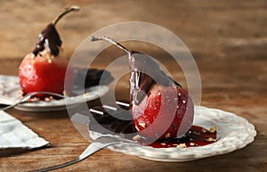 Delicious poached pear in red wine with chocolate sauce on plate