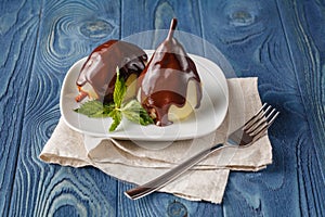 Delicious poached pears with chocolate syrup ready to serve