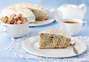 Delicious poppy seed cake with cup of tea on table