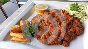 Delicious pork weiner schnitzel served with fried potatoes and pickled cabbage.