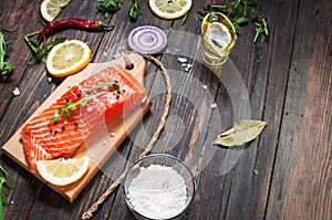 Delicious portion of fresh salmon fillet with aromatic herbs, spices and vegetables - healthy food, diet or cooking concept.