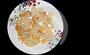 Delicious potato chips, on black background