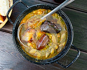 Pote asturiano. morcilla and chorizo served in black bowl.. photo