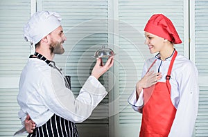 Delicious proposal. Join gourmet lifestyle. Man chef offer dessert or meal under cloche to girl. Will you eat my meal