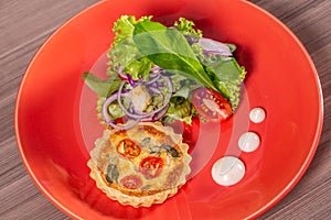 Delicious quiche with salad, served in colorful crockery