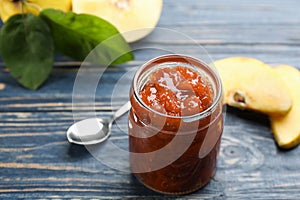 Delicious quince jam and fruits on blue wooden table