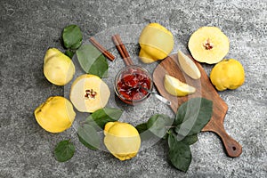 Delicious quince jam and fruits on grey table, flat lay