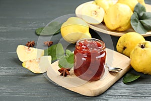 Delicious quince jam and fruits on grey wooden table
