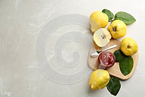 Delicious quince jam and fruits on light grey marble table, flat lay. Space for text
