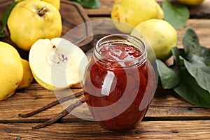 Delicious quince jam and fruits with vanilla on wooden table, closeup