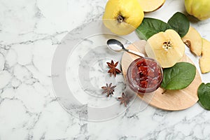 Delicious quince jam and fruits on white marble table, flat lay. Space for text