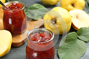 Delicious quince jam on grey table, closeup