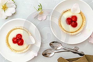 Delicious red raspberry strawberry whipped creamy tartlets,cakes.gourmet confection dessert on plate with latte coffee