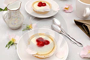 Delicious red raspberry strawberry whipped creamy tartlets,cakes.gourmet confection dessert on plate with latte coffee,milk.sweet