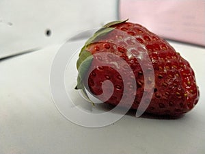 The delicious red strawberry is occurring in the white texture surface for diet meal