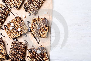 Delicious rice crispy treats on white wooden table. Space for text
