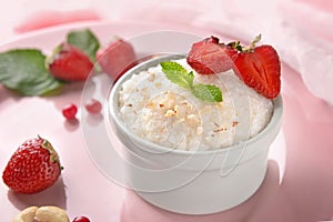 Delicious rice pudding with berries in bowl on color plate