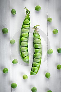 Delicious ripe green peas lying on a wooden table.