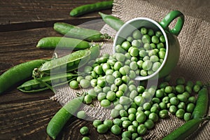 Delicious ripe green peas lying on a wooden table.