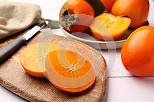 Delicious ripe juicy persimmons on wooden board, closeup